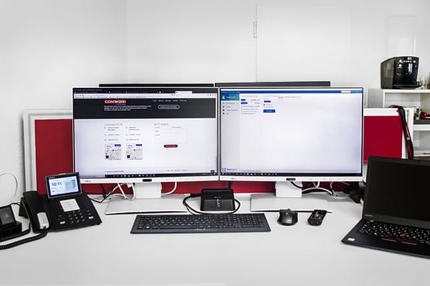 Moderner IT-Arbeitsplatz mit zwei Monitoren, Laptop und Telefon – COMWORX IT Website und Cloud-Lösungen für Unternehmen