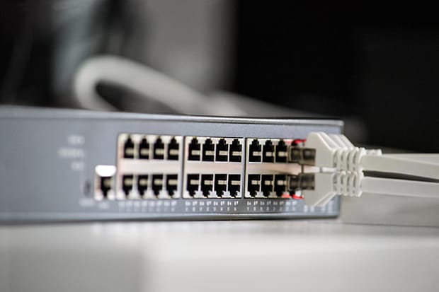 Professioneller Netzwerk-Switch mit eingesteckten Ethernet-Kabeln – stabile IT-Infrastruktur und Netzwerktechnik für Unternehmen